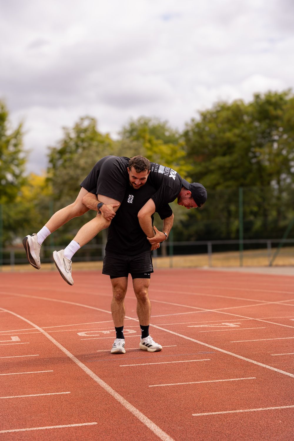 A member carrying a training partner over his shoulders on the track