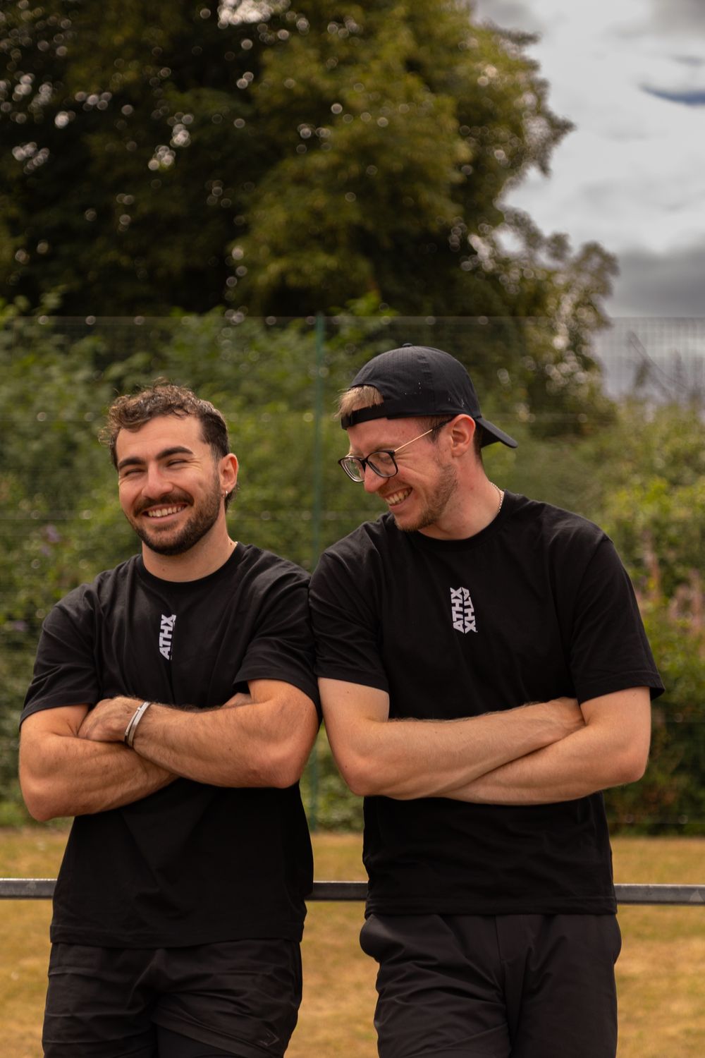 Lewis Long and Alex Fagen laughing together with their arms crossed